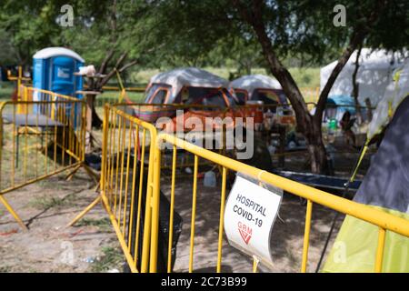 Matamoros, Messico. 13 luglio 2020. Un cartello avverte che la zona è riservata ai pazienti e al personale per tenere il pubblico lontano dalla zona di isolamento. Attualmente ci sono 23 persone che aspettano in isolamento per essere testate o per i risultati dei loro test del coronavirus. 3 dei residenti del campo hanno provato positivi per il virus. Ci sono circa 1,500 persone che vivono in tende all'interno di una zona recintata fuori del parco mentre attendono le loro audizioni di asilo negli Stati Uniti d'America. Credit: Cripps/Alamy Live News Foto Stock