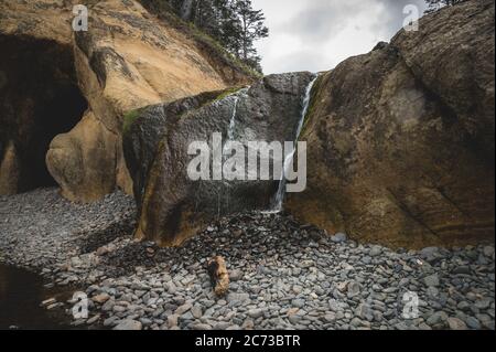 Cascata e grotte sulla spiaggia all'Hug Point state Park in Oregon. Foto Stock