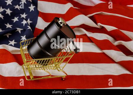 Un barile di petrolio di prezzi del petrolio in calo su un fondo di bandiera americana Foto Stock