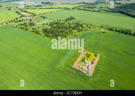 veduta aerea del paesaggio rurale con piccola fattoria tra verdi campi coltivati Foto Stock