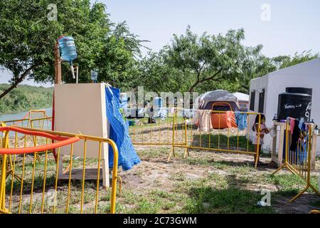 Matamoros, Messico. 13 luglio 2020. I bagni sono realizzati in modo makeshift e si trovano sul retro dell'area di isolamento, sulle rive del Rio Grande. Attualmente ci sono 23 persone che aspettano in una zona di isolamento per essere testate o per i risultati dei loro test del coronavirus. 3 dei residenti del campo hanno provato positivi per il virus. Ci sono circa 1,500 persone che vivono in tende all'interno di una zona recintata fuori del parco mentre attendono le loro audizioni di asilo dagli Stati Uniti d'America. Credit: SOPA Images Limited/Alamy Live News Foto Stock