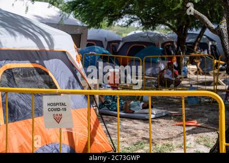 Matamoros, Messico. 13 luglio 2020. Un segno che delimita il bordo dell'area di isolamento. Attualmente ci sono 23 persone che aspettano in una zona di isolamento per essere testate o per i risultati dei loro test del coronavirus. 3 dei residenti del campo hanno provato positivi per il virus. Ci sono circa 1,500 persone che vivono in tende all'interno di una zona recintata fuori del parco mentre attendono le loro audizioni di asilo dagli Stati Uniti d'America. Credit: SOPA Images Limited/Alamy Live News Foto Stock