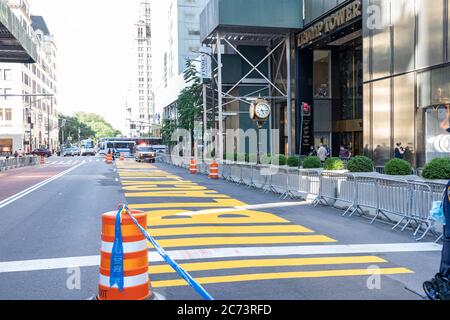 Un passerby scatta foto di un murale Black Lives Matter dipinto sulla Quinta Avenue di fronte alla Trump Tower di New York. Come uno di una serie di murales Black Lives Matter da dipingere in tutti e cinque i quartieri di New York City attira turisti e manifestanti su entrambi i lati del movimento politico. Foto Stock