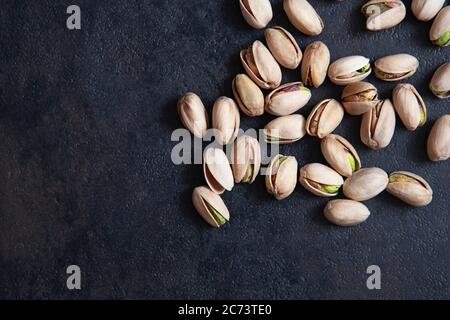 Pistacchi arrosto su fondo scuro. Snack sano. Foto Stock