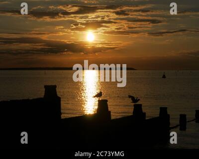 Tramonto su Whitstable, Kent, Regno Unito, guardando verso l'isola di Sheppey Foto Stock