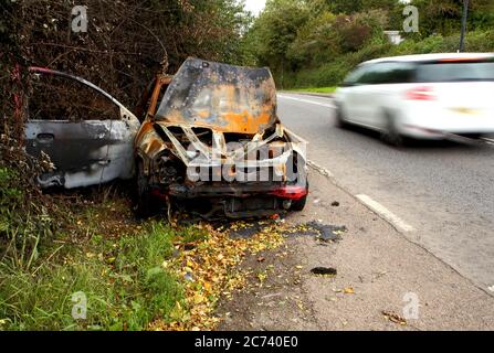 Si è schiantato, distrutto e bruciato auto abbandonate a sinistra accanto al lato di un vicolo del paese. Foto Stock