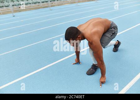 un ragazzo sportivo e ambizioso che fa esercizi per le gambe di st lo stadio. foto vista laterale a lunghezza intera Foto Stock