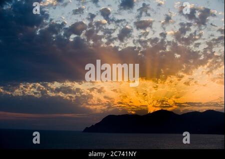 Europa, Italia, Liguria, Ligure. Spettacolare tramonto con nuvole su Punta Mesco nelle cinque Terre del Mar Ligure. Foto Stock