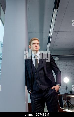 ritratto di giovane bell'uomo caucasico in ufficio esecutivo, guardare seriamente la macchina fotografica, indossando il tuxedo Foto Stock