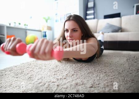 Donna a casa facendo fitness con manubri. Foto Stock