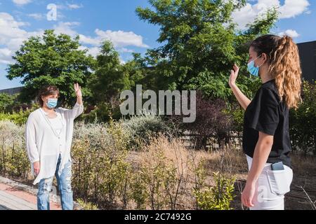 Nuovo normale. Distanza sociale. Due persone si salutano mantenendo una distanza di sicurezza. Pandemia. Dispositivi coronavirus. Coronavirus. Covid-19. Sicuro Foto Stock