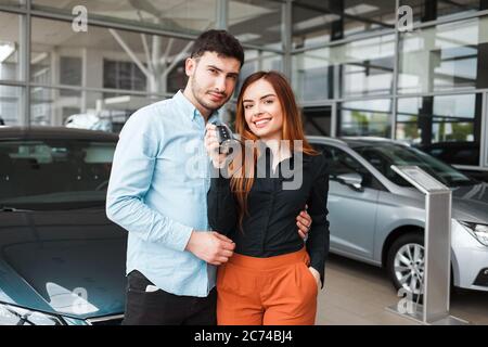 Felice coppia di famiglia con una chiave per la loro nuova auto Foto Stock