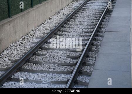 Semplice ferrovia vista dall'alto sfondo. Allenati con la texture della pista. Guida in acciaio su ghiaia. Buon e conveniente modo di trasporto per il carico. Viaggio e viaggio. Foto Stock