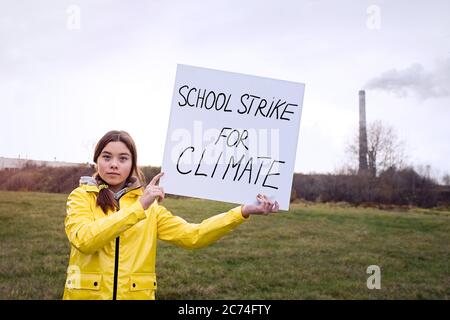 Ragazza adolescente che tiene il cartello durante lo sciopero globale per il cambiamento climatico Foto Stock