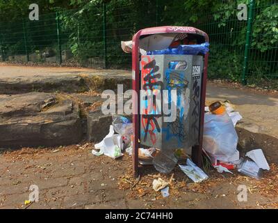 Riempito eccessivamente trash can su un parcheggio, Germania Foto Stock