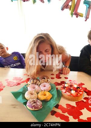 Donna che soffia fuori le candele di compleanno, Germania Foto Stock