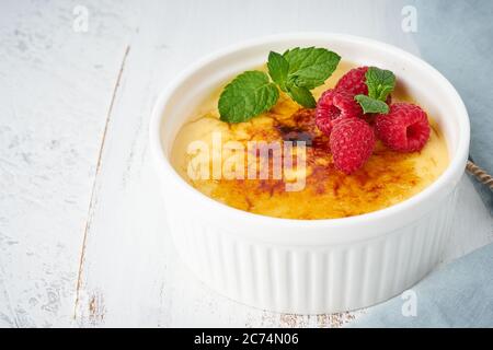 Crema catalana, dessert spagnolo con frutti di bosco in ramekin bianco, vista laterale, ricetta mappa fodmap Foto Stock