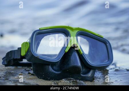 maschera per immersioni si trova sulla sabbia, la riva sullo sfondo dell'onda Foto Stock