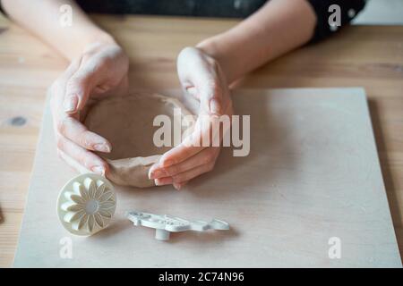 Donna che fa ceramica, mani closeup, sfondo sfocato, fuoco su vasai, palme con ceramica. Trasformare la passione in un lavoro Foto Stock