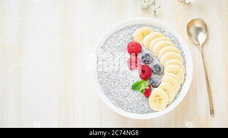 Chia pudding in ciotola con lamponi freschi, mirtilli. Vista dall'alto, spazio per la copia, banner. Foto Stock