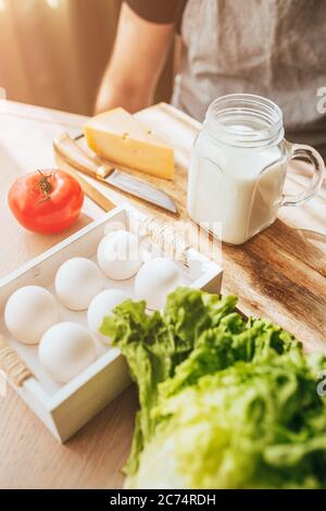 Prodotti naturali da fattoria sulla tavola - uova di pollo, latte, formaggio e verdure - sana e abbondante colazione sana senza OGM Foto Stock