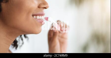 Igiene orale. Primo piano di Black Woman spazzolando i suoi denti perfetti bianchi Foto Stock