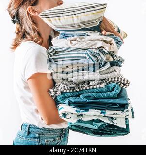 Donna prende in mani grandi coperte di pile blu e beige, asciugamani e altri tessuti domestici Foto Stock