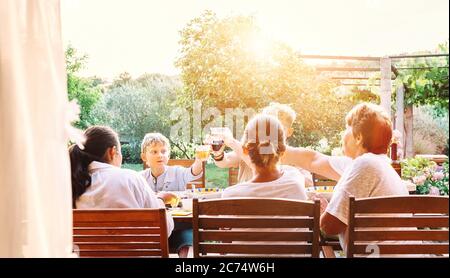 La grande famiglia multigenerazionale ha cena. Serata estiva in giardino Foto Stock