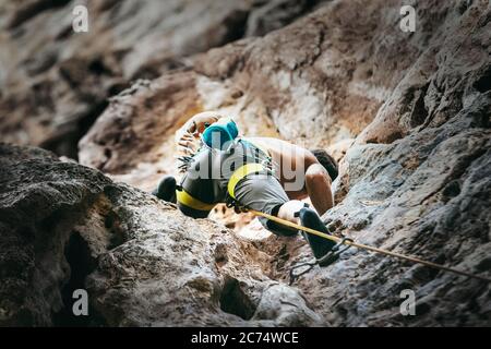 Scalatore di montagna su percorso di arrampicata sulla parete di roccia. Immagine concettuale di tempo attivo. Foto Stock