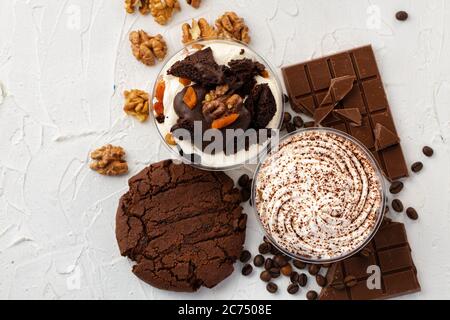 Dessert in mousse di cacao in scatola trasparente di plastica su superficie grigia Foto Stock