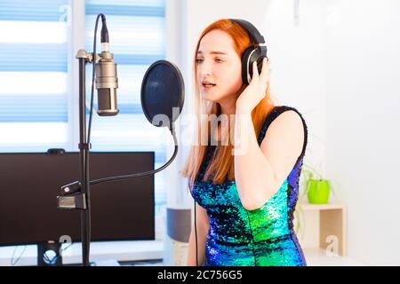 La ragazza canta a casa utilizzando attrezzature professionali Foto Stock