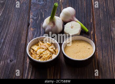 Aglio fresco, essiccato e macinato su superficie di legno Foto Stock