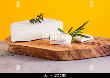 Pezzi di formaggio camembert su tagliere di legno Foto Stock