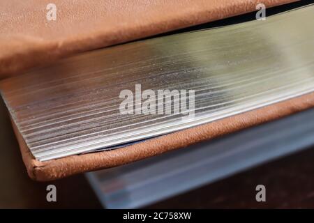 Primo piano di un vecchio libro con pagine dorate. Vista laterale. Foto Stock