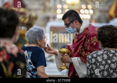 Minori celebra Santa Trofimena, protettrice della Città del gusto. Il legame che unisce il popolo di Minorca al santo patrono è molto profondo. Quest'anno, tuttavia, il festival non si è tenuto come in passato, a causa dell' emergenza sanitaria rappresentata dal Covid-19. La Santa Messa è stata celebrata dall'Arcivescovo Mons. Orazio Soricelli, nel pieno rispetto delle norme vigenti, volte a garantire la prevenzione dal contagio, la festa è stata ridotta all'essenziale nel suo apparato civile ed esterno: I volontari, prima dell'inizio della Santa Messa, svolgono i sanitizzati Foto Stock