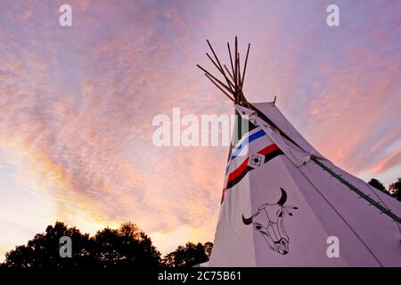 TIPI con decorazioni artistiche tradizionali di capi di bestiame dei nativi americani dipinte a mano in un campo glamping con in un campeggio festival, Norfolk Foto Stock