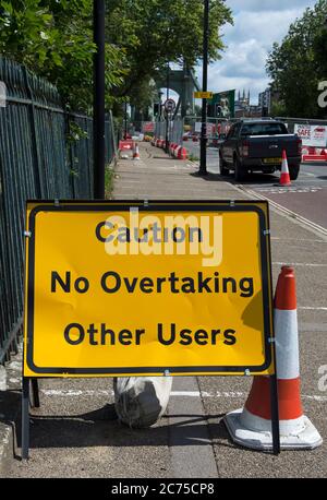 attenzione non sorpassi altri utenti, insolito segnale stradale britannico sulla strada sud per hammersmith ponte, londra, inghilterra Foto Stock