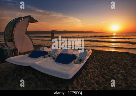 Due catamarani sulla spiaggia. Spiaggia di sabbia al tramonto. Foto Stock