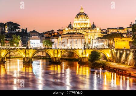 Basilica di San Pietro in Vaticano e Ponte Sant'Angelo sul Tevere al tramonto. Romantica serata con il paesaggio urbano di Roma. Foto Stock