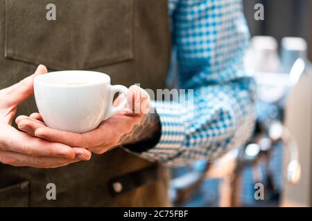 Primo piano di Man Barista che tiene fresco caffè scuro. Colazione perfetta. Concetto di soggiorno a casa. Preparazione del caffè da Amateur in cucina domestica Foto Stock