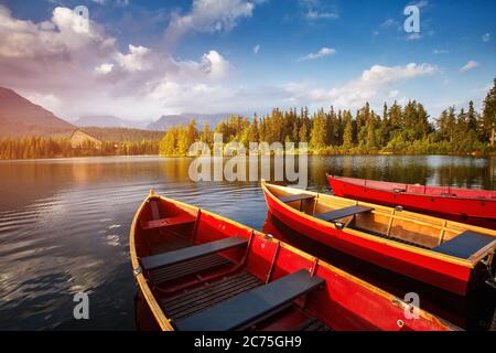 Barche rosse sull'acqua che brilla alla luce del sole al tramonto. Foto Stock