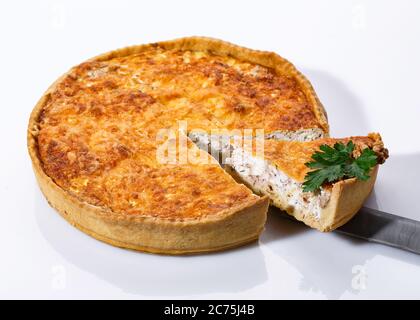 Presa della torta di funghi deliziosa con una spatola da cucina. Torta vegetale profumata su sfondo bianco. Foto Stock