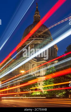 Un passaggio di Routemaster red bus londinese crea percorsi di luce davanti alla famosa cattedrale di San Paolo a Londra centrale durante la sera ore blu. Foto Stock