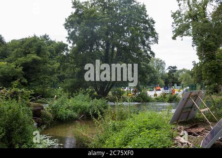 Denham, Regno Unito. 13 luglio 2020. Le guardie di sicurezza dell'HS2 guardano attraverso il fiume Colne in un campo di protezione della fauna selvatica istituito da attivisti della ribellione dell'HS2 per cercare di impedire il riinstradamento dei piloni in congiunzione con il progetto ferroviario ad alta velocità. HS2 è attualmente previsto per costare circa £106 miliardi e rimarrà un contributo netto alle emissioni di CO2 durante i suoi 120 anni di vita previsti. Credit: Mark Kerrison/Alamy Live News Foto Stock