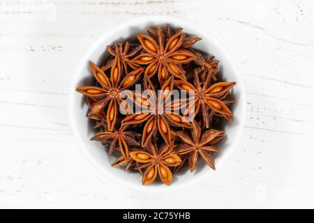 Stella anice stella anice di Natale spezie erba da sopra ciotola su un legno di legno di tavola Foto Stock