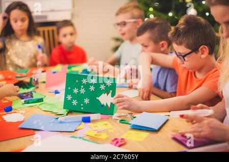 I bambini si sono impegnati nella creazione di carte di Natale fatte a mano Foto Stock