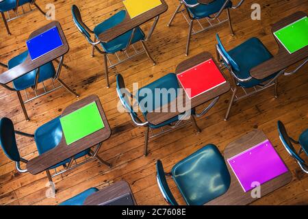 Un gruppo di scrivanie della scuola con i notebook sopra. Foto Stock