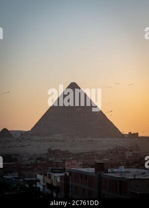 Vista delle piramidi al tramonto dal tetto di giza Foto Stock