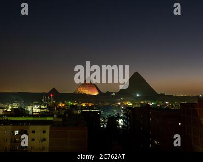 piramidi con skyline di giza di notte con spettacolo di luci Foto Stock