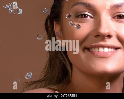 Rinfrescate il viso, lavate con acqua pulita, concetto. Un tuffo d'acqua e un ritratto di una giovane bella donna, cura della pelle, pulizia del viso. T Foto Stock